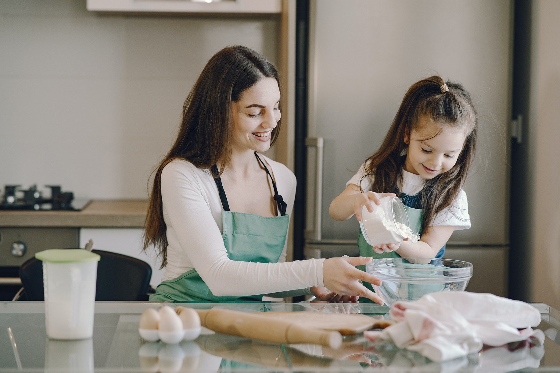 Mãe e filha a cozinhar juntas na bancada da cozinha